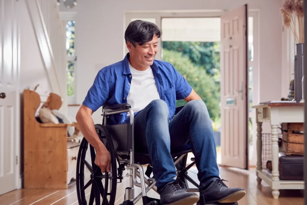 Disabled man in wheelchair in home setting smiling